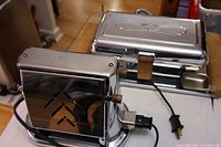 Toaster front and flat grill showing overall chrome finish, cords attached