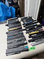 All 26 laptop batteries arranged on table