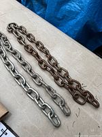 Galvanized and rusted bike locking chains laid on tabletop