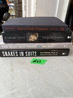 Stack of four paperback books showing titles and authors