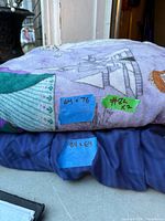 Stacked blankets showing prints, colours and dimension labels