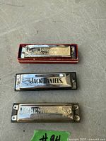 Top-down view of three harmonicas showing brand engravings and condition