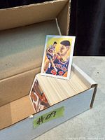 Open cardboard box filled with stacked basketball trading cards; top card Brad Daugherty Fleer Pro-Vision visible