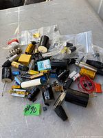Pile of assorted capacitors, connectors, fuse holder, wire and small components on tabletop