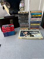 Overview showing 8-track case, stacks of music cassettes and sealed blank tapes