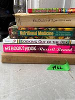 Stack of seven assorted books showing spines and titles