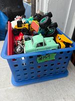 assorted toy vehicles inside blue basket