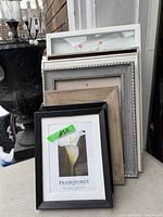 Stack of five empty frames and one framed floral print
