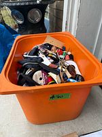 Orange bin containing assorted sewing, knitting and crochet supplies