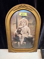 Front view of antique gilded frame with convex glass and child with dog print