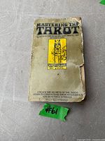 Front cover of paperback showing title, card illustration, visible tears and wear