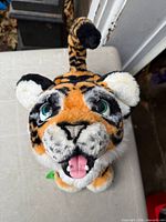 Top view of interactive tiger plush showing head, tail and striping