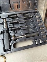 Open Jobmate case showing impact driver, ratchet handle, bits, sockets and adapters