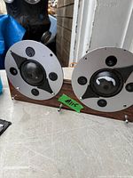 Front view of both circular speaker drivers on wood strip