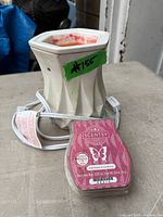 Ceramic Scentsy electric wax warmer with attached power cord beside Cashmere & Corduroy wax bar clamshell