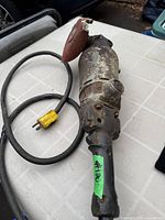 Overall view of vintage angle grinder with disc and cord