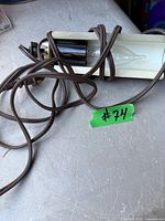 Front view of brass-tone picture light with bulb and cord