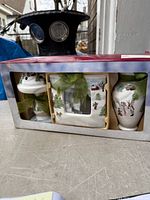 Front view of boxed winter scene ceramic gift set showing lidded jar, photo frame and vase