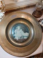 Full view of brass plaque showing outer rim and central image