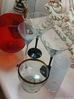 Group shot showing five of the six glasses including red snifter, two martinis, Don Julio margarita glass, and frosted tumbler