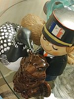 Group shot of three ceramic coin banks: French policeman, brown beaver, black-and-white loon