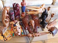 overview of assorted wood carvings on glass table