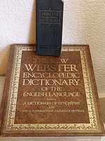 Abbott's vest-pocket dictionary placed on top of large New Webster Encyclopedic Dictionary