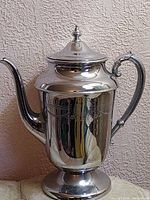 Front view of chromium plated coffee pot showing overall design