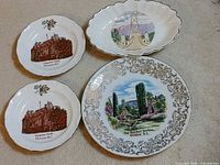 Four souvenir dishes laid out: two Empress Hotel candy dishes, one oval Lion’s Gate dish, one round Butchart Gardens plate