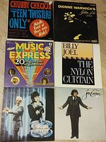 Six sample album covers displayed on tabletop: Chubby Checker, Dionne Warwick, Music Express, Billy Joel, Linda Ronstadt, Joe Cocker