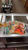 All five comics fanned on glass counter
