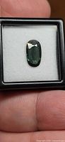 Top view of oval green sapphire in display box