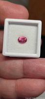 Front view of oval hot pink tourmaline in display box
