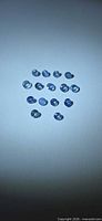 Loose round blue sapphires arranged on neutral background