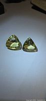 Two pale yellow trillion-cut citrines side by side on white surface