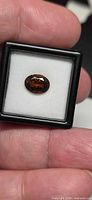 Oval orange tourmaline in gem box, frontal view