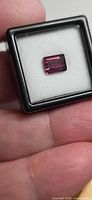Rectangular emerald-cut Rubelite tourmaline in display case