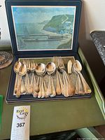 Full lot showing flatware arranged on placemat inside presentation board
