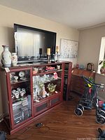 Full view of multimedia cabinet with TV atop showing doors and shelves