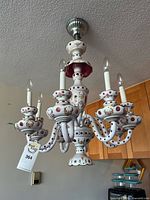 Full view of porcelain six-arm chandelier hanging from ceiling