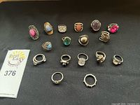 All rings laid out on black background showing variety