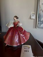 Front view of Royal Doulton “First Waltz” figurine on shelf with height tag