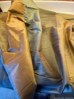 Folded striped silk fabric showing amber and grey tones