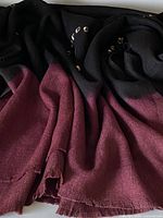 Folded wool throw showing burgundy border and brown field