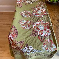 Full view of tablecloth draped over table showing floral pattern and border