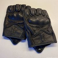 Full view of both gloves showing overall design, fingerless cut, knuckle guards, wrist closures and snap