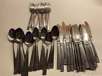 Full lot showing knives, spoons, forks with matching patterned handles