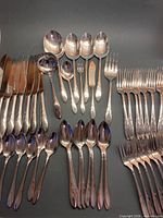 Overall view of knives, soup spoons, assorted serving utensils, forks and teaspoons