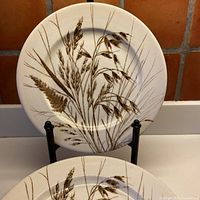 Front view showing two wheat-pattern plates on stand