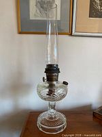 Full view of clear glass Aladdin kerosene lamp with chimney